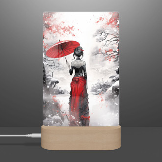 Lampa zasnežená krajina so ženou držiacou dáždnik